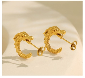 Detailed macro view of golden dragon head stud earrings with intricate 3D metal scales