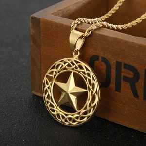 Macro view of 18K gold plated star pendant with Celtic knot and rope chain on wood