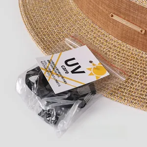 Détail d'un chapeau de soleil en paille marron avec étiquettes UV et mentonnière noire