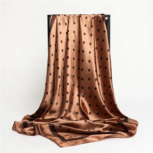 Detailed view of brown satin square scarf with black polka dots and high-gloss texture