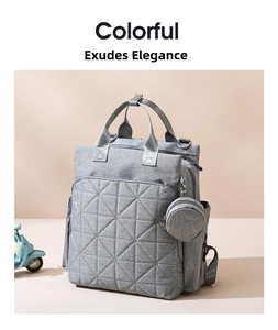 Close-up of a grey quilted diaper bag with geometric patterns and a round coin pouch