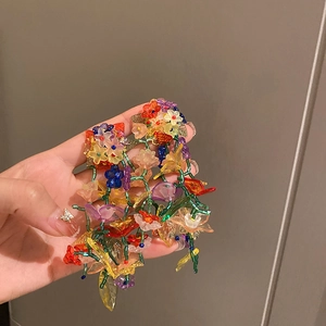 Dettaglio macro di orecchini a fiore fatti a mano con perline colorate e nappe vivaci