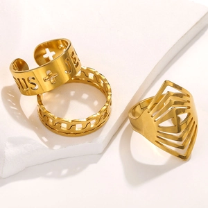 Detailed close-up of three gold adjustable stainless steel rings on a white stone background