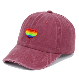 Detail of rainbow heart embroidery and distressed brim on vintage washed cotton baseball cap