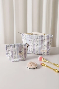 Detail view of purple floral cosmetic bags with ribbon bow and flower zipper charm