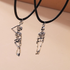 Close-up of retro silver skeleton hand pendants on black cords for Halloween style