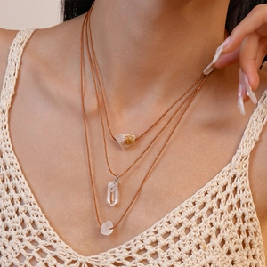 Close-up of three-layered bohemian necklace with raw natural crystals on a model