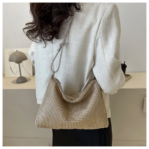 Detail of elegant gold rhinestone shoulder bag paired with tweed jacket