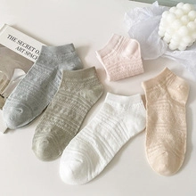 Flat lay of five pairs of pastel low-cut cotton socks with ribbed cuffs and soft texture