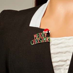 Detailed view of Merry Christmas brooch with Santa hat on a black suit lapel