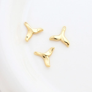 Detailed view of three 14k gold-plated whale tail charms for DIY jewelry making