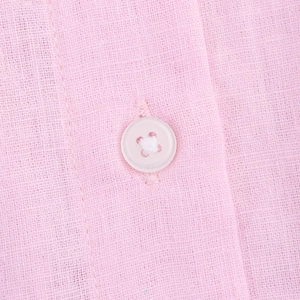 Detail of pink cotton-linen fabric texture with matching four-hole button closure
