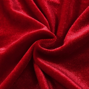 Macro shot of luxurious red velvet fabric showing soft texture and glossy sheen