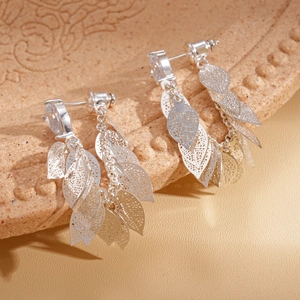 Boucles d'oreilles pampilles en argent avec feuilles ajourées et zircons sur un plateau
