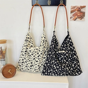 Vue détaillée des sacs cabas en toile florale avec anses en cuir et étiquette Sozakka