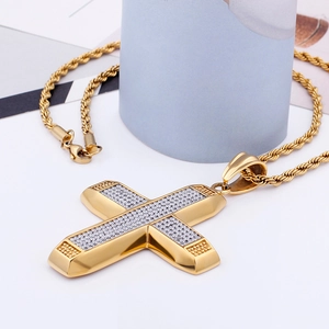 Macro shot of iced-out cross pendants in gold and silver with twist chain necklaces