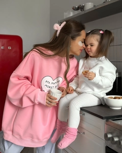 Détail d'un sweat oversize rose avec imprimé cœur et texte russe sur tenue de famille