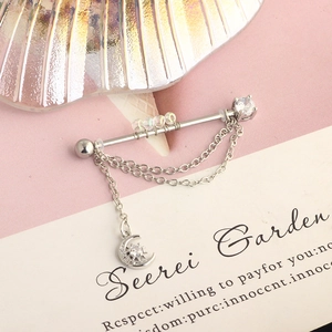 Detail of silver industrial barbell featuring moon and star pendant with crystal chains