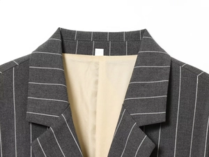 Détail d'un revers de blazer gris à rayures avec doublure beige et texture fine
