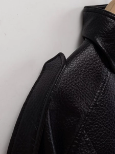 Détail de l'épaulette d'une veste en cuir noir avec des surpiqûres précises et texture