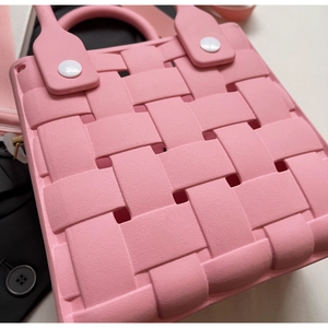 Close-up of pink EVA beach bag showing woven texture and white handle fasteners
