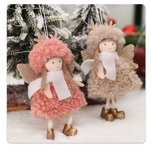 Detail of plush Christmas angel dolls with gold antlers and wings in snowy scene
