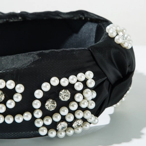 Detail of luxury mesh headband with intricate pearl and rhinestone floral pattern embroidery