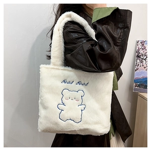 Détail du sac fourre-tout en peluche blanche avec broderie ours bleu et texte Beat Beat