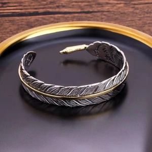 Vintage adjustable feather open cuff bracelet in silver and gold tone metal