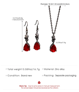 Dettaglio del set collana e orecchini a teschio con pietre preziose rosse a goccia