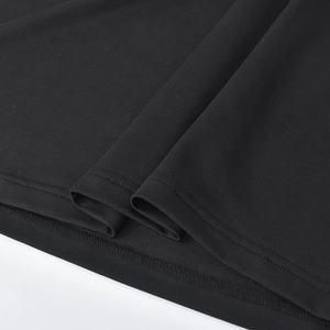 Close-up of black knit fabric showing high-quality double-needle hem and texture details