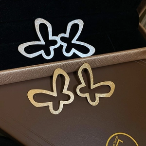 Minimalist hollow butterfly stud earrings in silver and gold with glitter texture finish