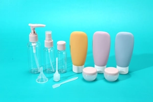 Set da viaggio 11 pezzi con flaconi in silicone e spray su sfondo ciano professionale