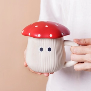 Detail of cute red mushroom ceramic mug with white polka dot lid and textured surface