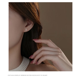 Close-up of minimalist hollow teardrop sterling silver stud earring on a female ear