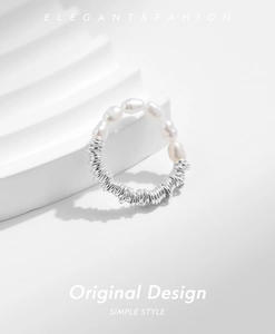 Macro view of Baroque pearls and silver beads on a flexible cord minimalist ring