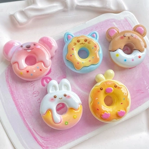 Macro view of five resin cartoon animal donut charms including bear and bunny styles