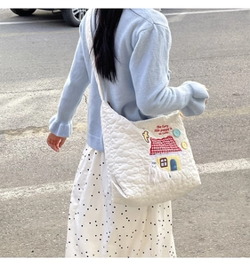 Street style view of white quilted tote bag featuring cute house and puppy embroidery