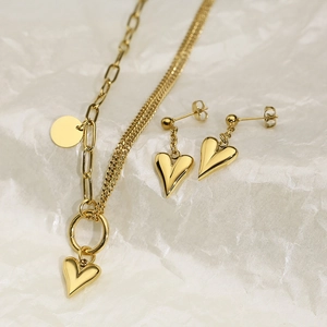 Detailed view of golden double-layered heart necklace and matching stud earrings set