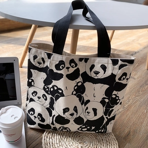 Detail view of canvas tote bag with cute panda print on a table with morning sunlight