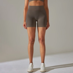 Detailed texture of seamless high-waist taupe yoga shorts on female model with soft lighting