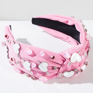 Detailed view of pink fabric knot headband with rhinestone arrows and heart charms