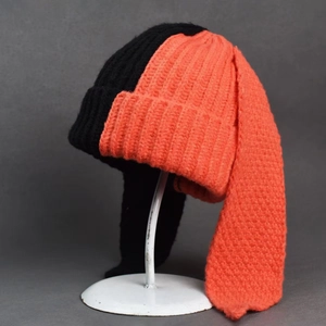 Detail of knit beanie with long bunny ears in contrasting black and orange
