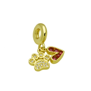 Macro detail of gold charm with a red heart and a sparkling white crystal paw print