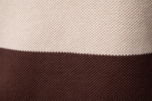 Nahaufnahme von zweifarbigem Strickstoff in Beige und Dunkelbraun mit feiner Textur