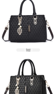 Front view of black handbag with geometric triangle pattern and gold leaf pendant