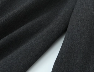 Dettaglio del tessuto twill grigio antracite che mostra la trama pregiata e il drappeggio