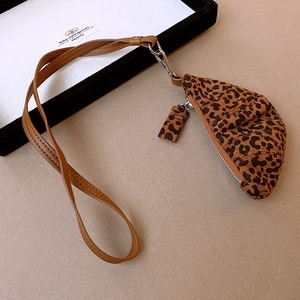 Detail view of leopard print faux leather crescent bag with silver zipper and strap
