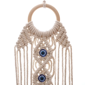Handwoven macrame wall hanging with evil eye beads and tassels in boho style