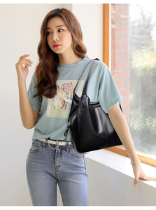 Detail of black pebbled leather tote bag with slim shoulder straps and high texture